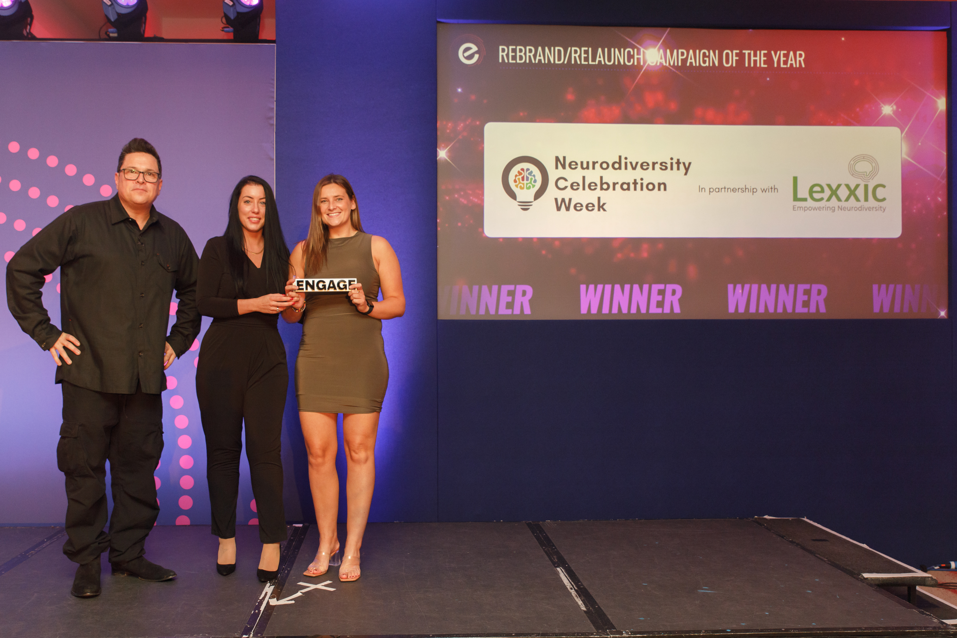 People holding an award on stage